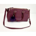 An Aspinal of London Burgundy Leather Hand/Shoulder Bag. Gold-tone hardware. Three zipped openings