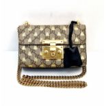A Gucci Padlock Monogram Canvas Bees' Crossbody Bag. Gilded furniture and gilded bee decoration