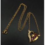 An 18 k yellow gold chain necklace with a heart pendant adorned with rubies and diamonds. Length: 43