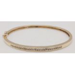 9K YELLOW GOLD DIAMOND SET BANGLE. 0.60CT DIAMOND. TOTAL WEIGHT 10.1G