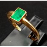 An 18K Yellow Gold Emerald Solitaire Ring. Size O. 2.08g total weight.