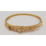A 22 K yellow gold, stone set, baby bangle. Size adjustable, weight; 5.2 g.