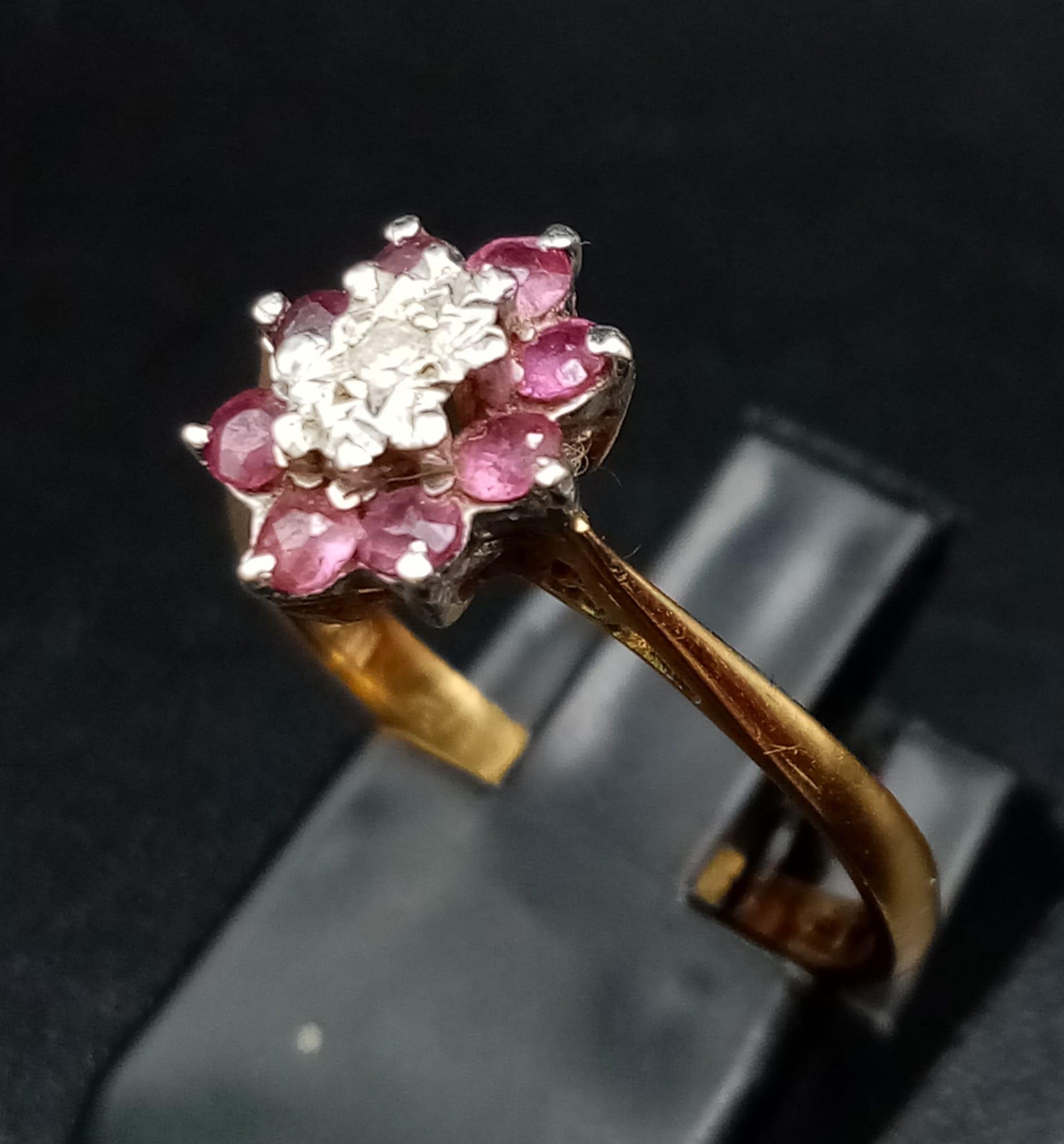 An 18K Yellow Gold Ruby and Diamond Ring. Central small diamond with a ruby gemstone halo. Size M - Image 2 of 5