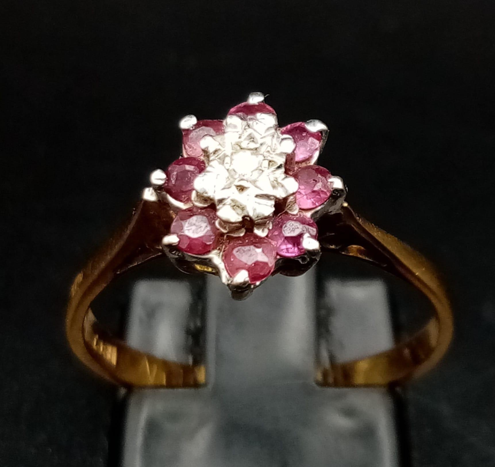 An 18K Yellow Gold Ruby and Diamond Ring. Central small diamond with a ruby gemstone halo. Size M