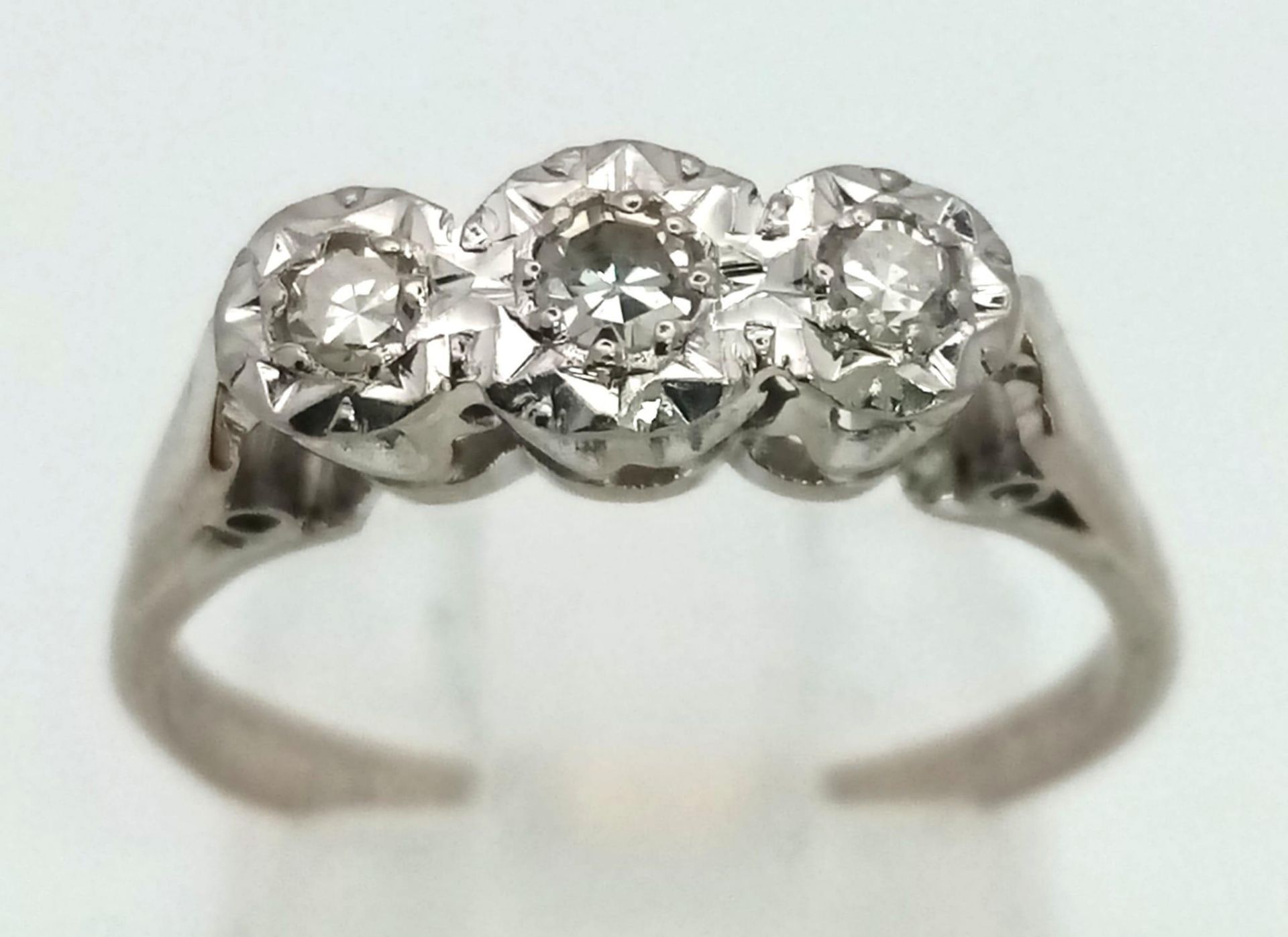 An 18K White Gold Three Stone Diamond Ring. Size N. 3.05g total weight.