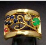 An 18 K yellow gold ring with an artistic design and adorned with an emerald cabochon, plus ruby,