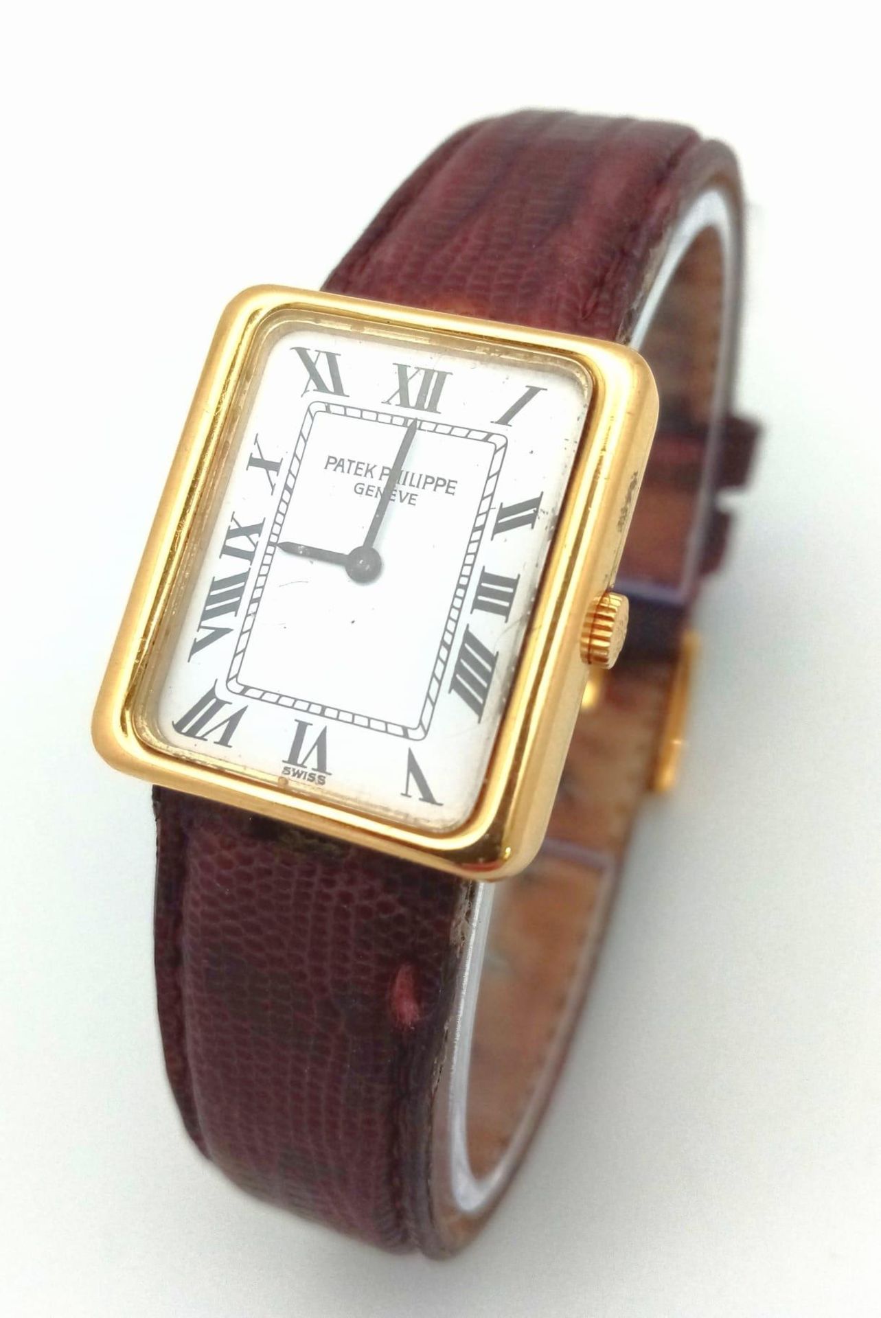 An 18 K yellow gold PATERK PHILIPPE Geneve watch. Case: 25 x 22 mm, white dial with Roman