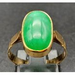 An 18K Yellow Gold Jade Ring. Green jade oval cabochon. Size O. 2.7g total weight.
