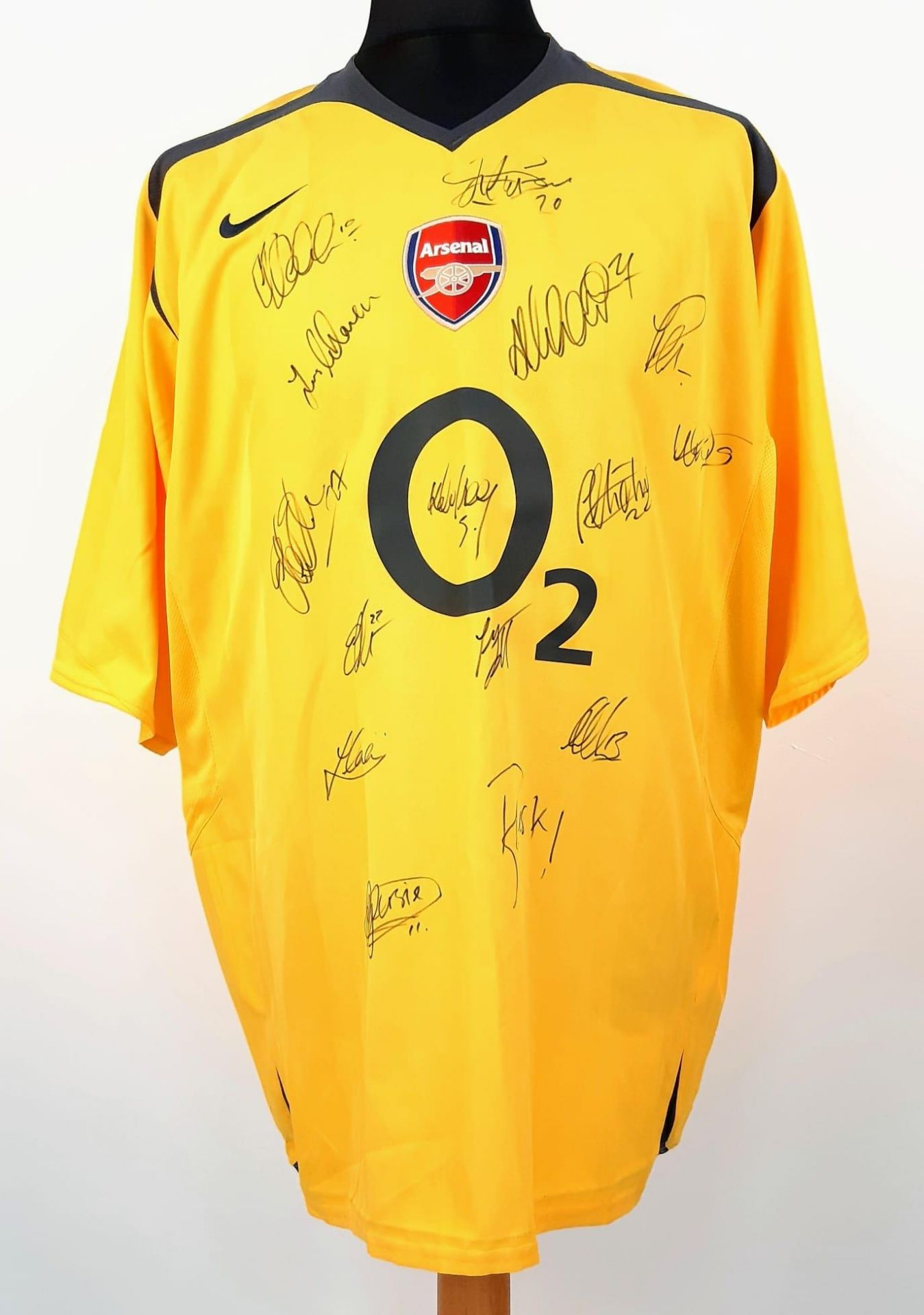 An Arsenal Football Club Signed 2006 Away O2 Yellow Shirt. Fifteen signatures including: Van Persie,