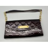 A Louis Vuitton Patent Leather Sunset Boulevard Bag. Monogram burgundy patent leather. Gold-tone