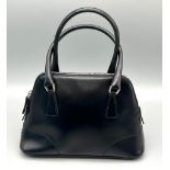 A Prada Black Leather Mini Handbag. Classic shape with twin handles. Prada metal logo. Comes with