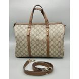 A Gucci Monogram Canvas Travel Bag. Leather handles and trim. Spacious textile interior with