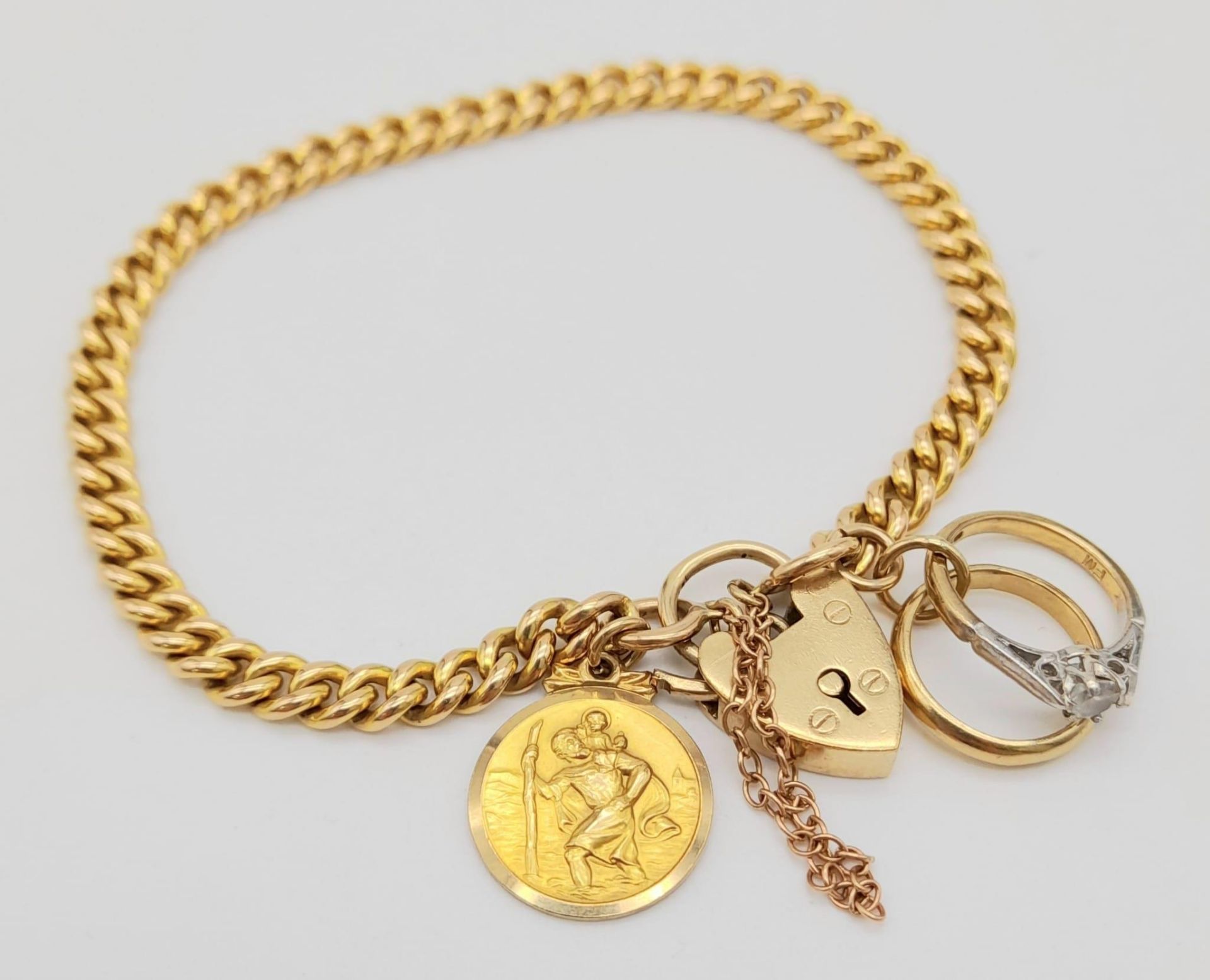 A Vintage 9K Yellow Gold Bracelet with Three 9K Yellow Gold Charms and a Heart Clasp. All links