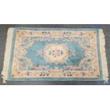 A VINTAGE HEAVY QUALITY CHINESE FRINGED RUG IN PALE BLUE WITH CLASSIC PATTERN . 150 X 92cms a/f