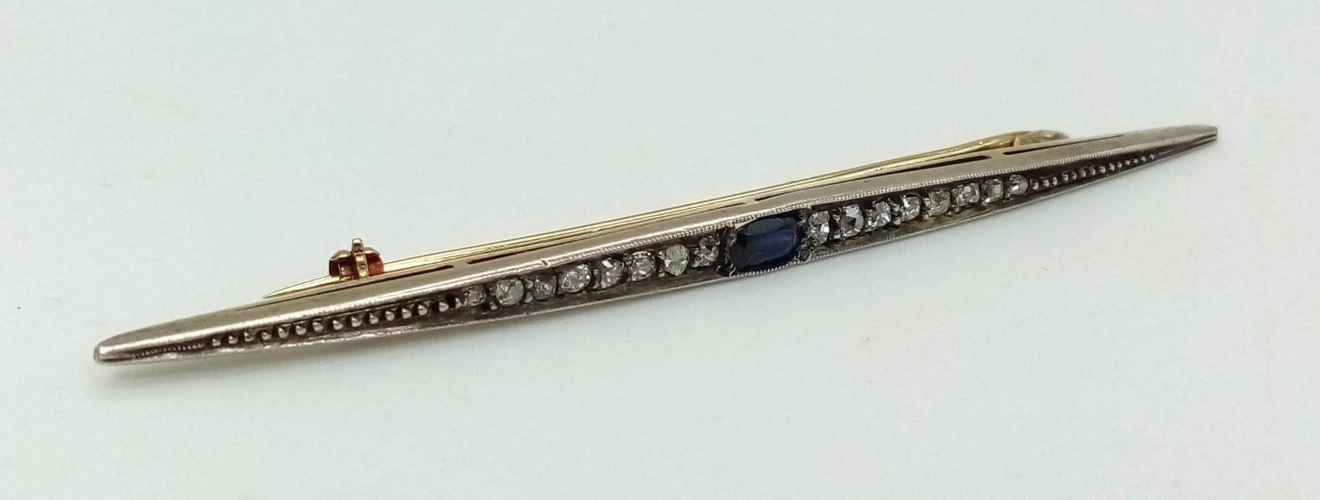 An antique yellow and white gold brooch with old cut diamonds and a blue sapphire. Length: 80 mm. In