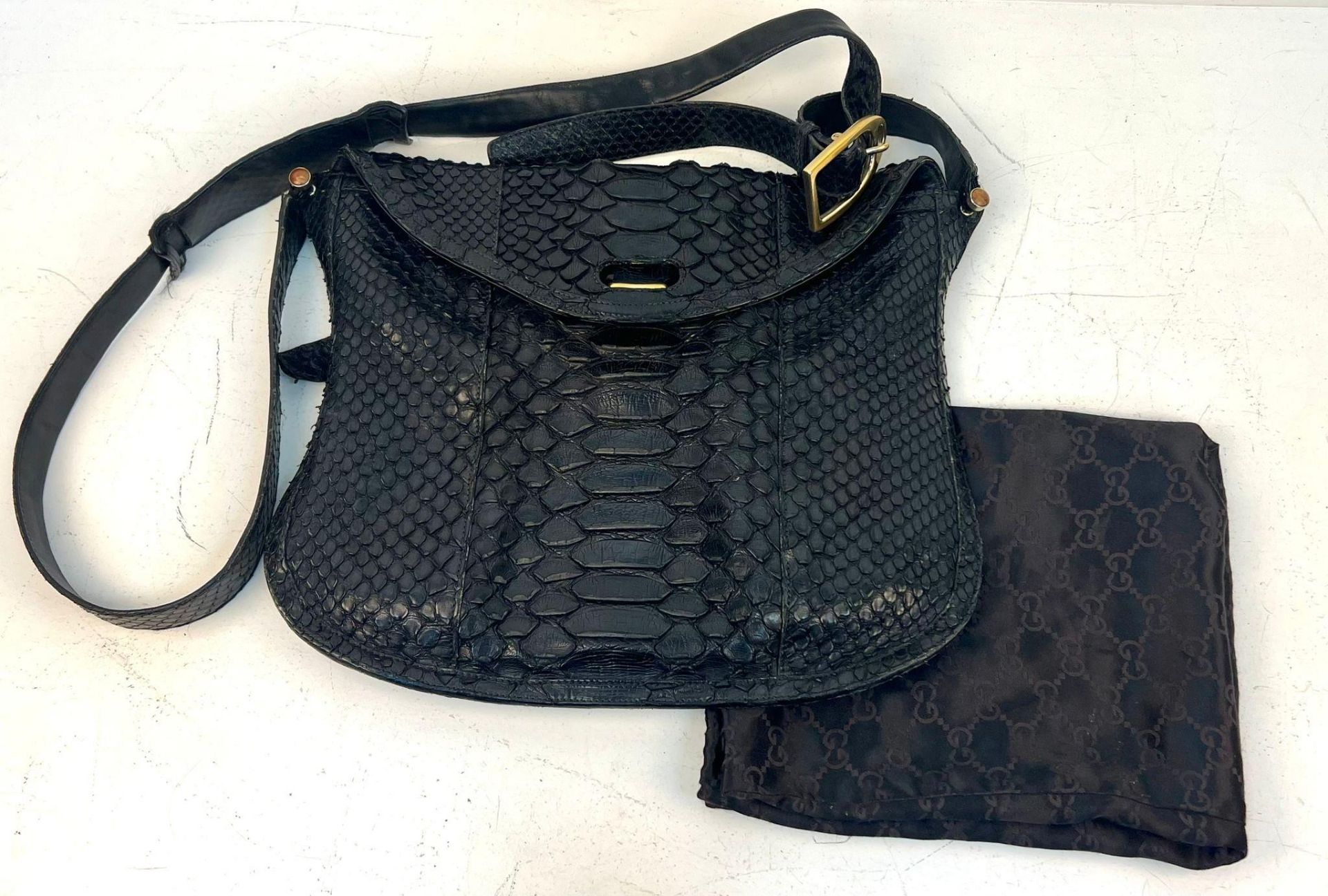 A Gucci Black Python/Snakeskin Shoulder Bag. Gold-tone hardware. Adjustable shoulder strap. Spacious