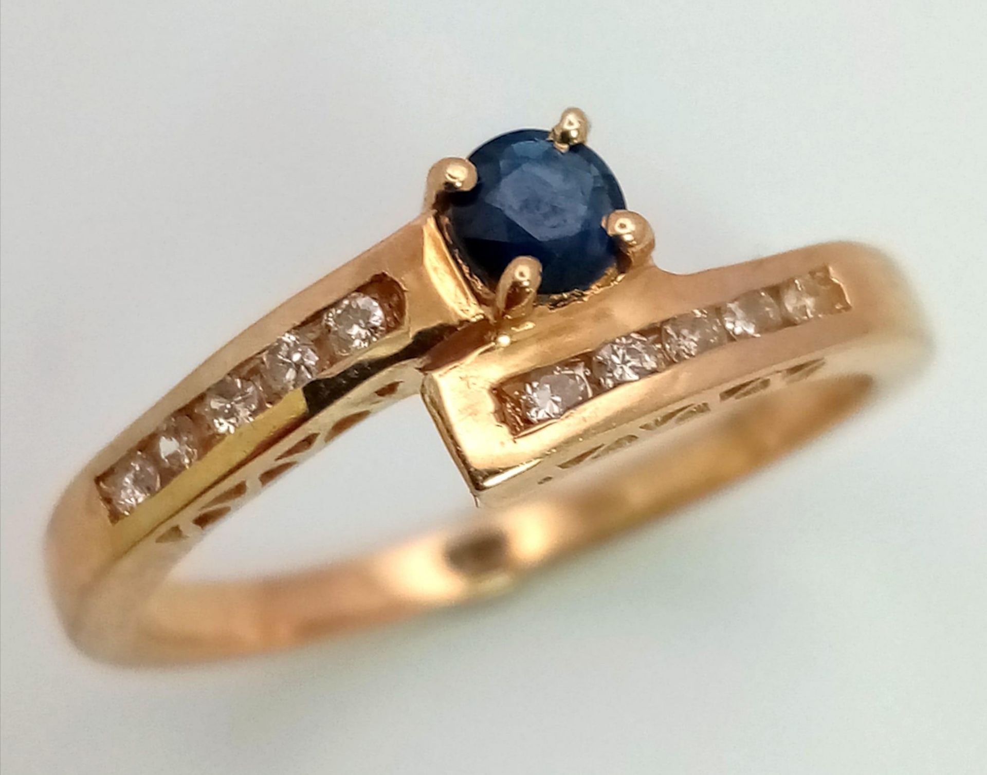 9K YELLOW GOLD DIAMOND & SAPPHIRE TWIST RING, SET WITH 0.15CT DIAMONDS AND 0.18CT SAPPHIRE, WEIGHT - Image 2 of 4