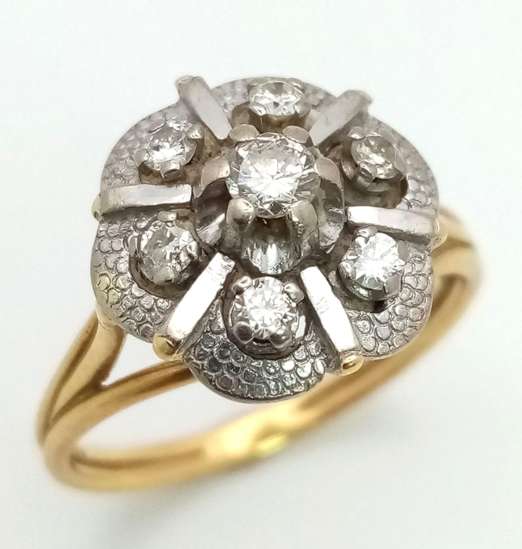 A Vintage 18K Yellow Gold and Diamond Floral Ring. Central petal-cut diamond surrounded by a halo of