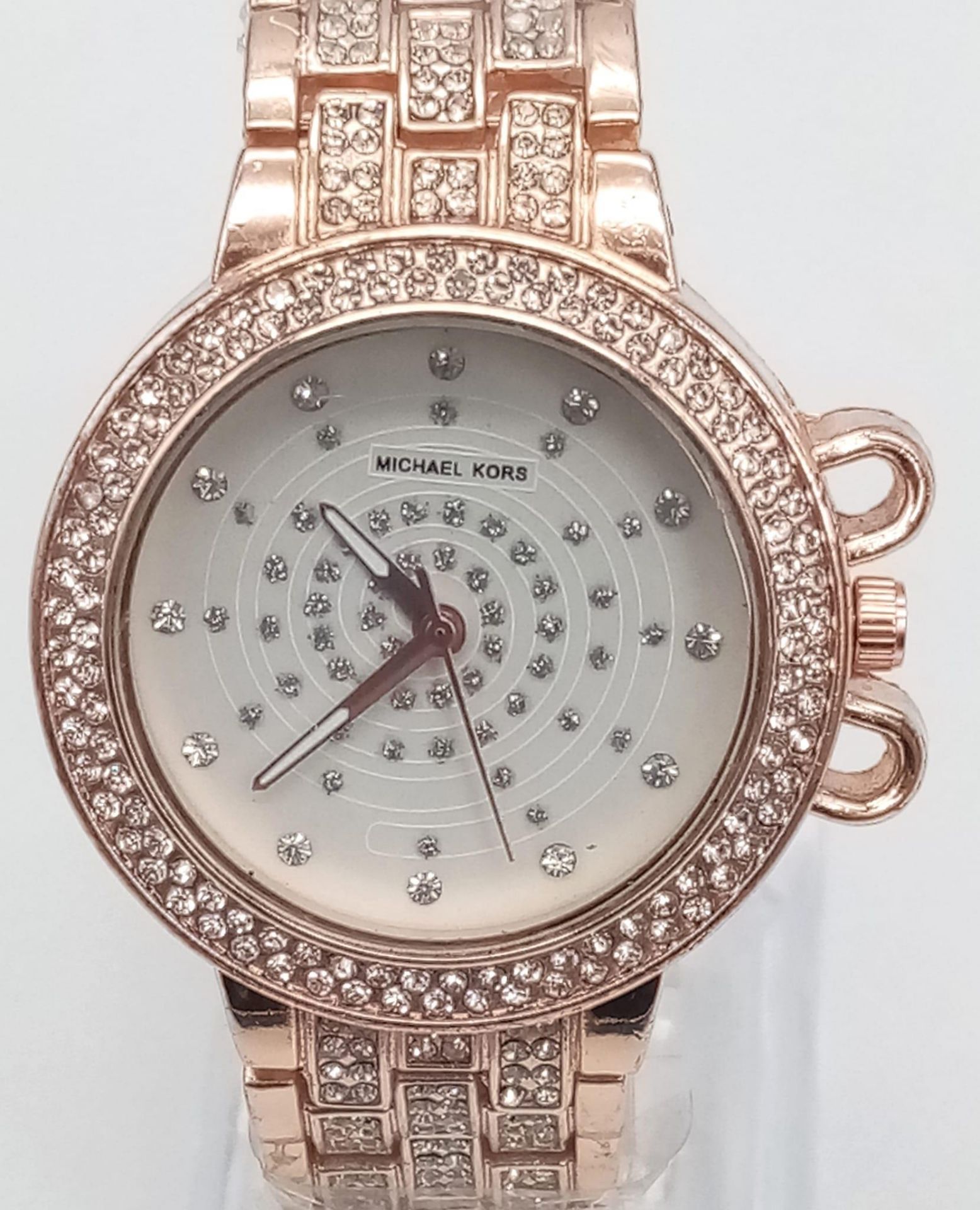 A LADIES MICHAEL KORS FACSIMILE WATCH IN ROSE GOLD TONE STONE SET BEZEL AND STRAP, FULL WORKING