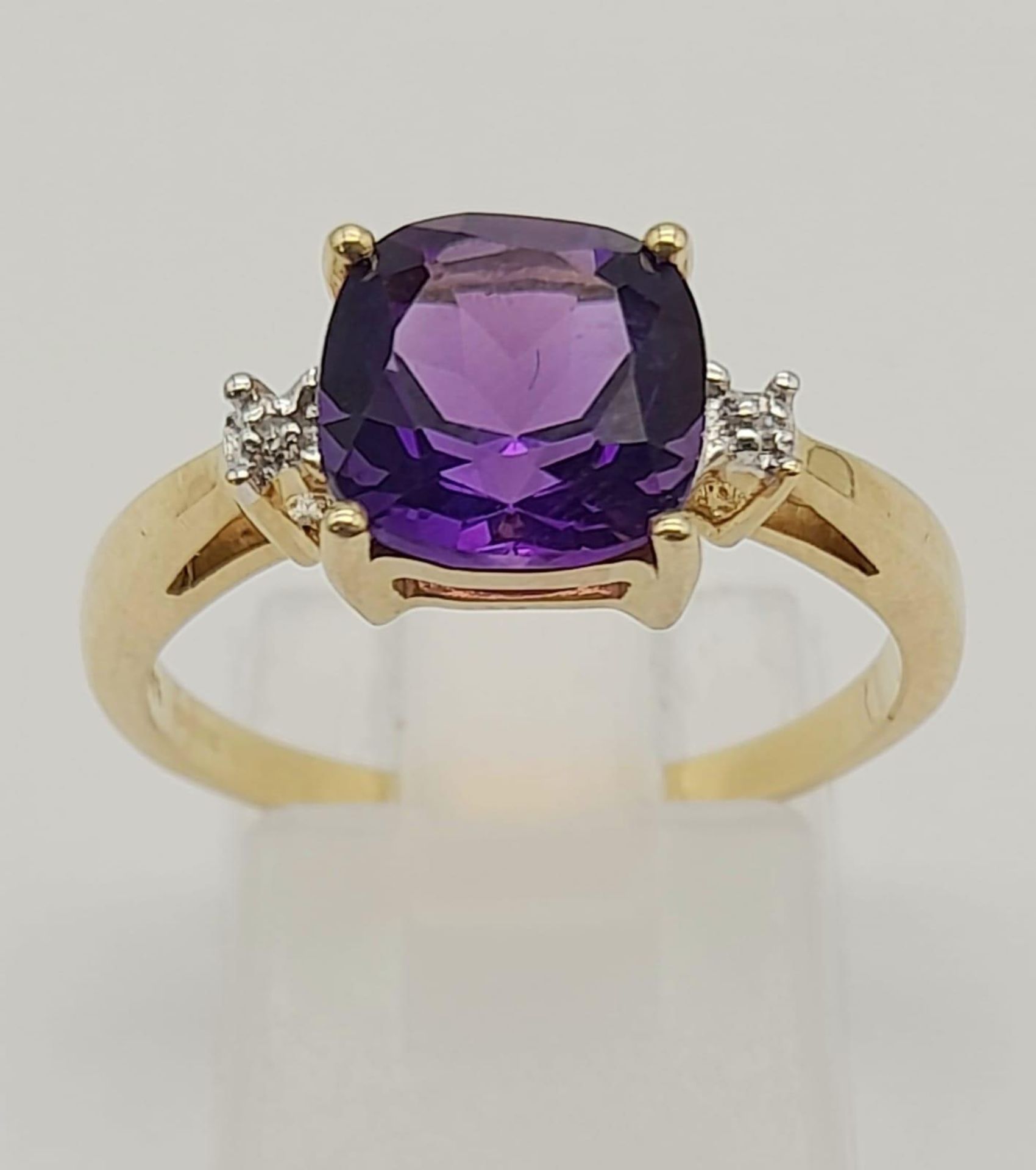 A 9K GOLD AMETHYST AND DIAMOND RING . 2.6gms size P