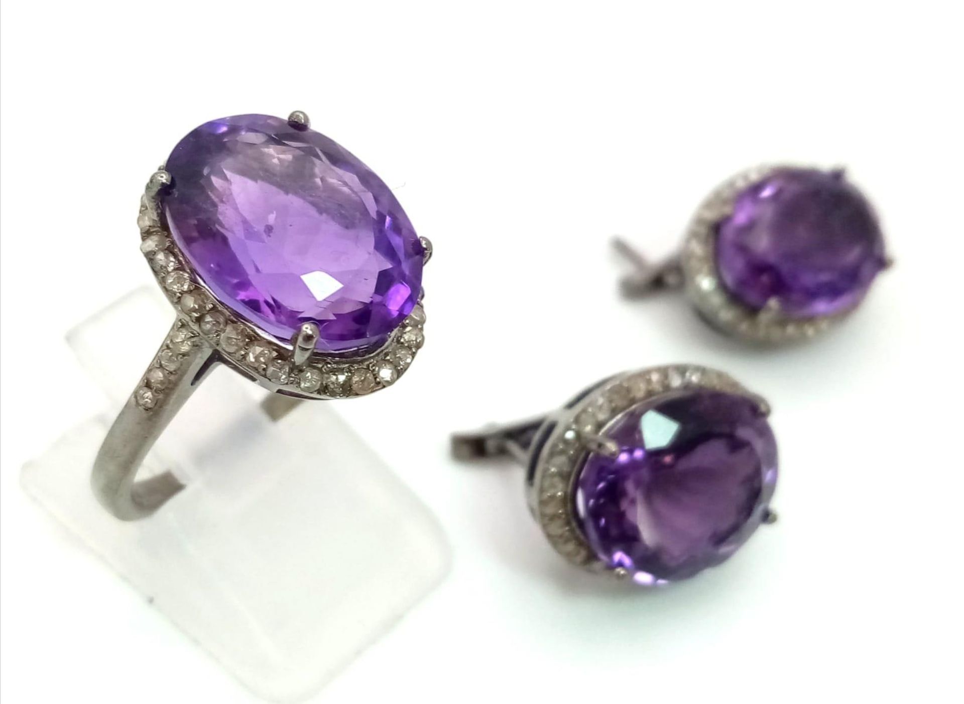 An Amethyst Gemstone Ring with a Matching Pair of Stud Earrings. Both with Diamond Accents. All