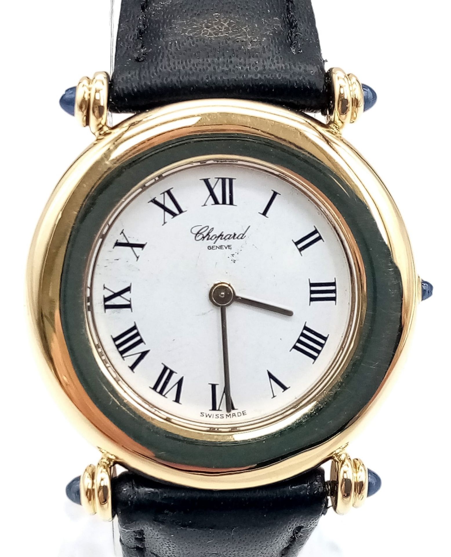 AN 18K GOLD LADIES CHOPARD WRIST WATCH WITH ROMAN NUMERALS , WITH BLACK LEATHER STRAP 27mm