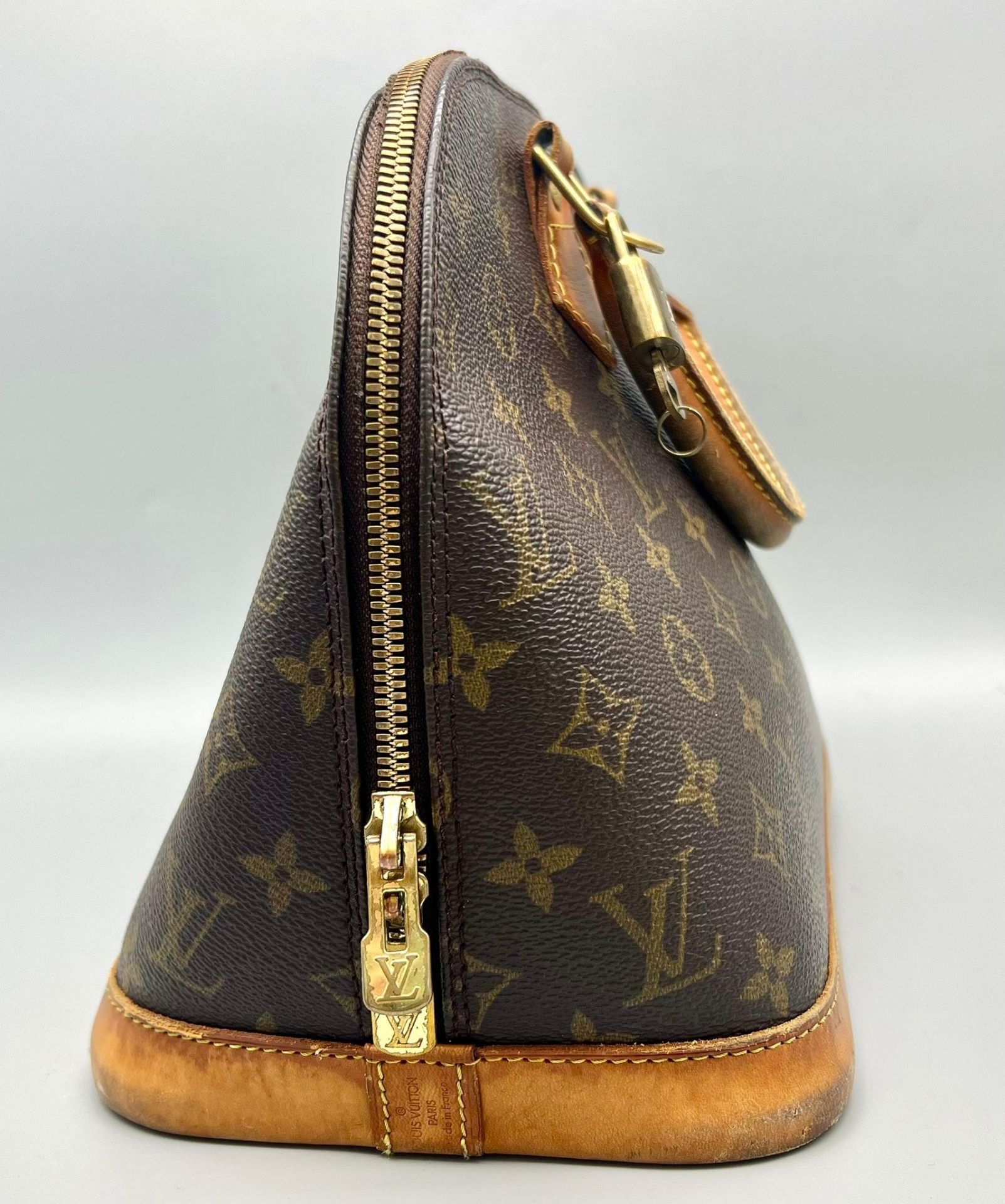 A Louis Vuitton Alma Monogram Canvas Bag. Brown leather handles with gilded lock and key. Brown - Bild 3 aus 7