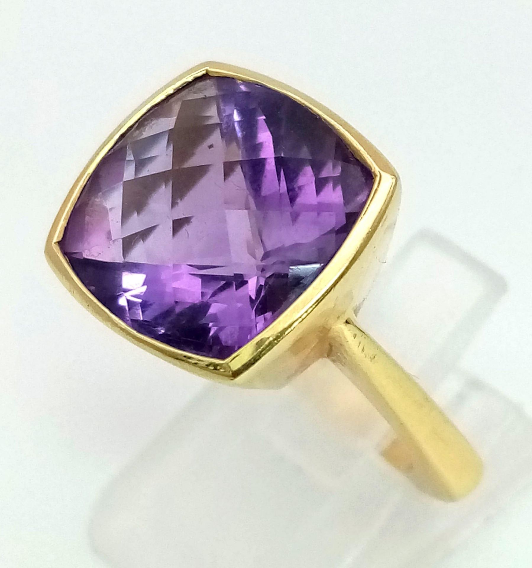 A DESIGNER 18K GOLD RING WITH BEAUTIFULLY FACETED AMETHYST CENTRE STONE. 9.7gms size I/J