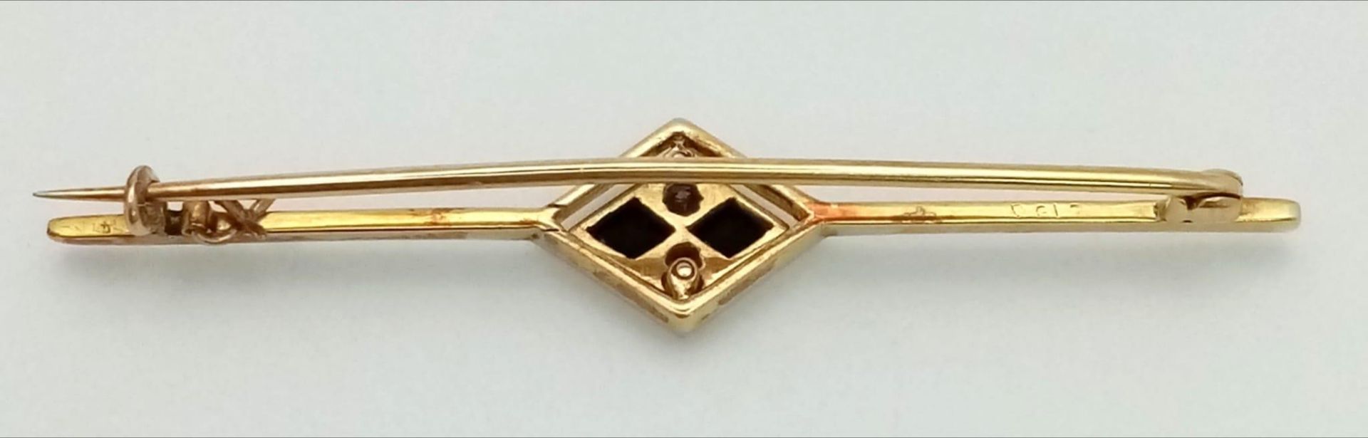 An Art Deco Diamond and Onyx Brooch in 18K Gold and Platinum. 5.5cm. 3.75g total weight. - Image 3 of 4