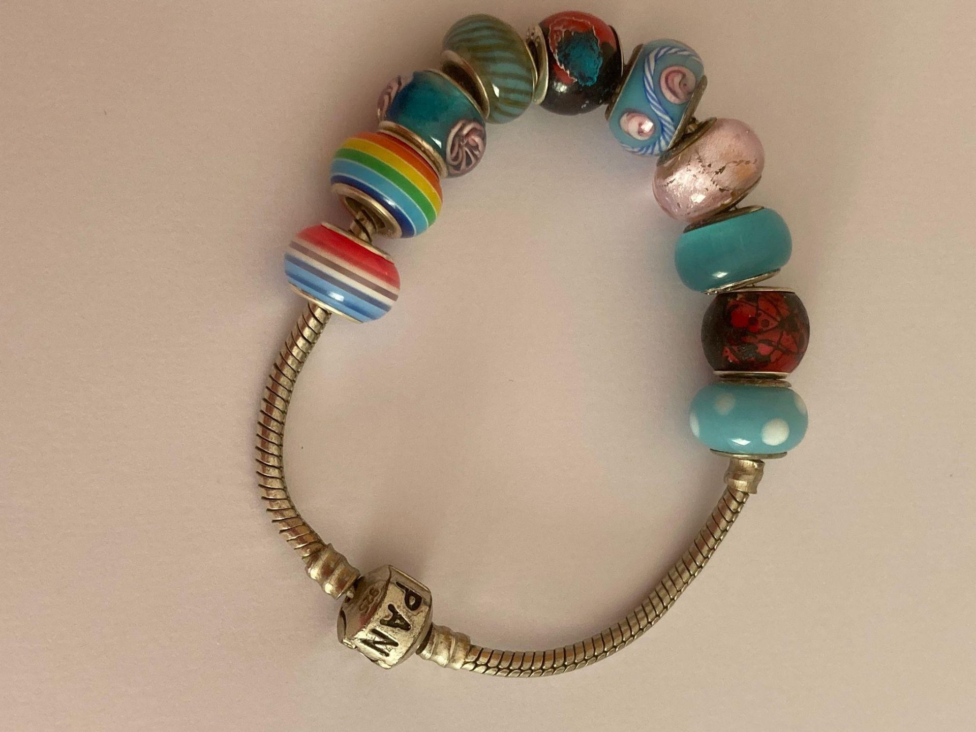 SILVER BRACELET having marking for PANDORA and set with SILVER CHARMS. To include silver/rainbow