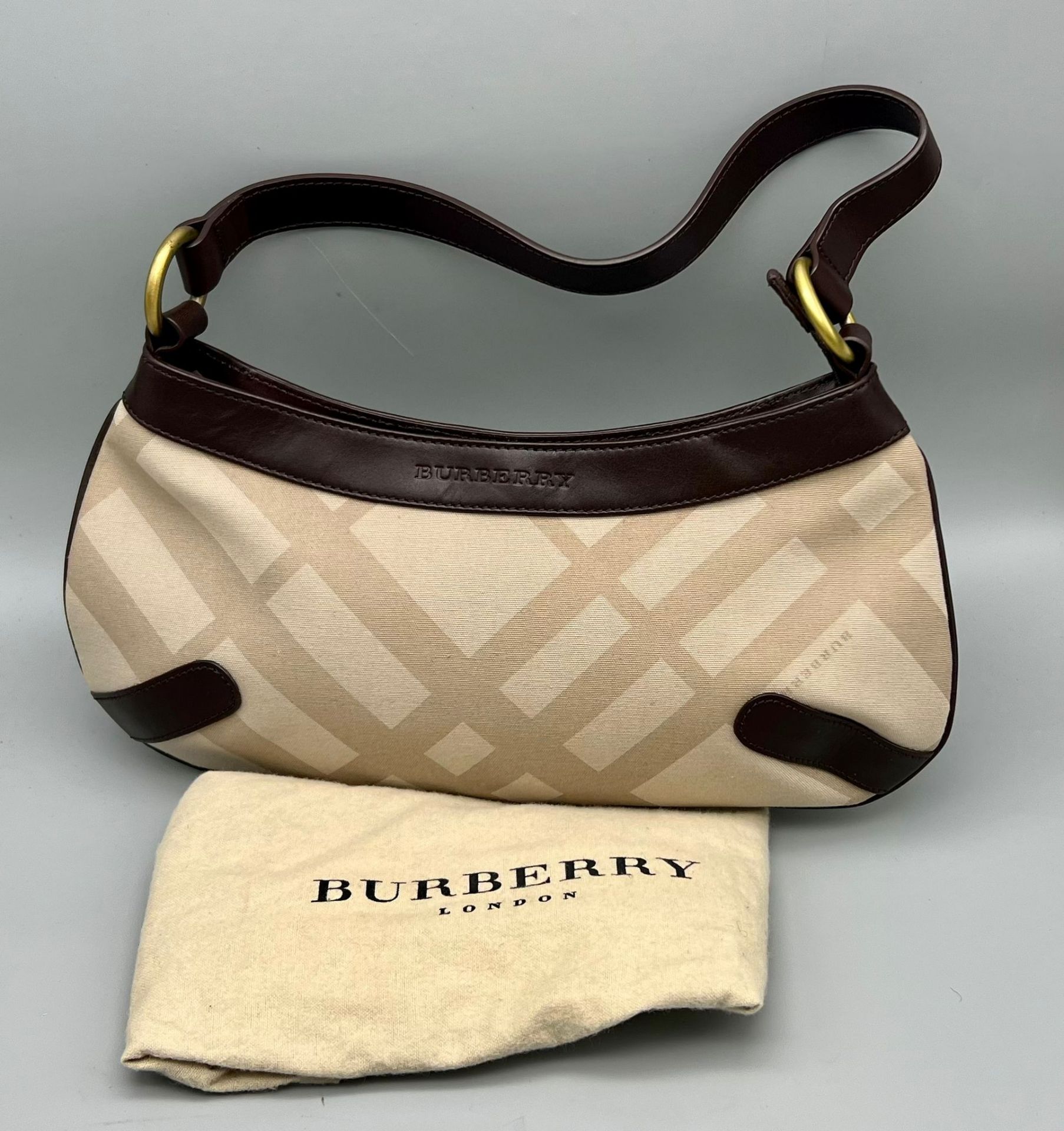 A Burberry Baguette Pouch Bag. Exterior beige canvas with leather handle and trim. Textile
