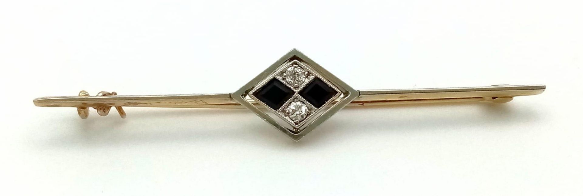 An Art Deco Diamond and Onyx Brooch in 18K Gold and Platinum. 5.5cm. 3.75g total weight. - Image 2 of 4