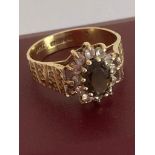 Attractive 9 carat GOLD RING Having textured shoulders and set with Garnet and clear stones to