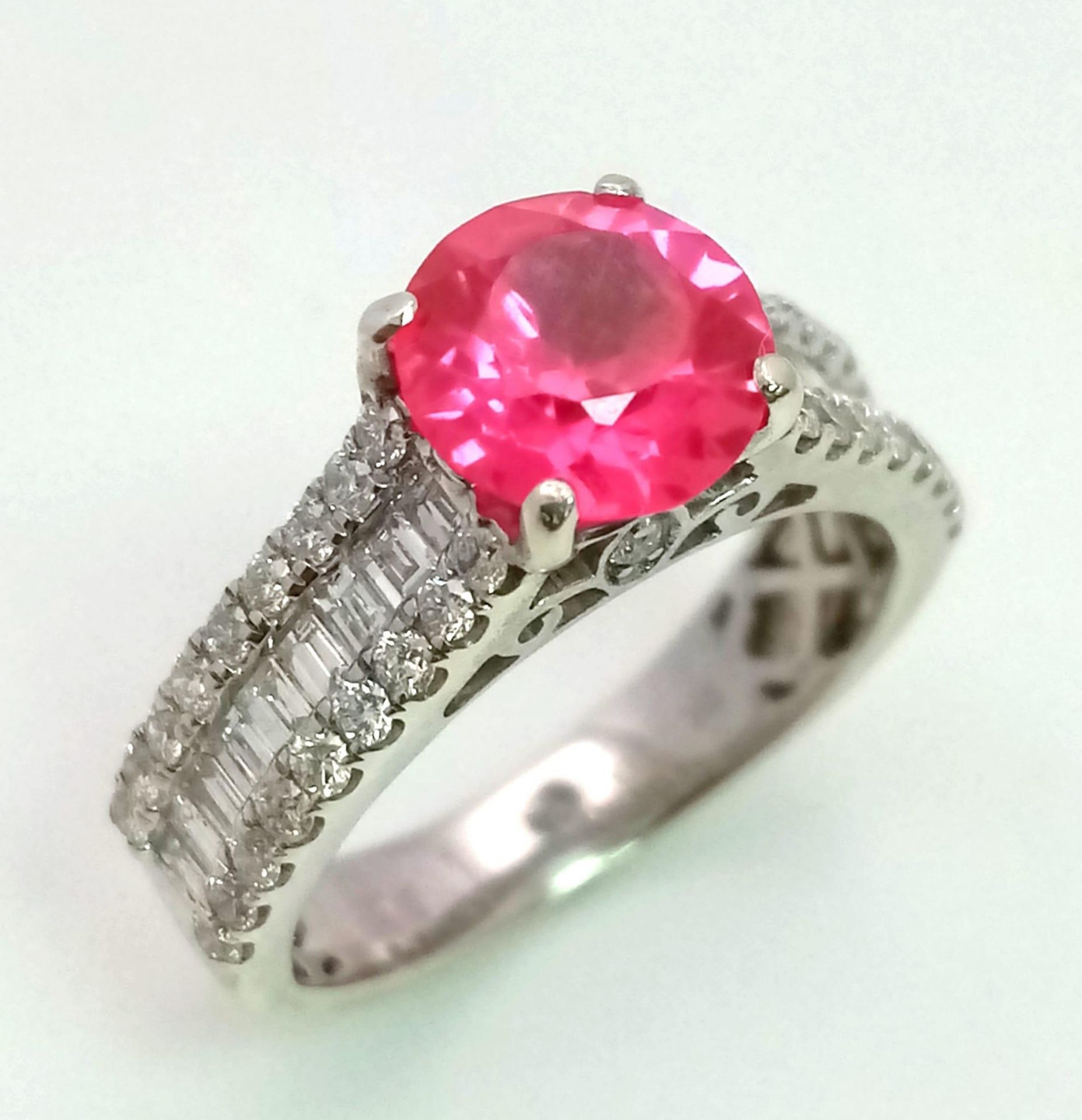 A 9 K white gold ring with a round cut rubelite and diamonds on the shoulders of the ring. Size: