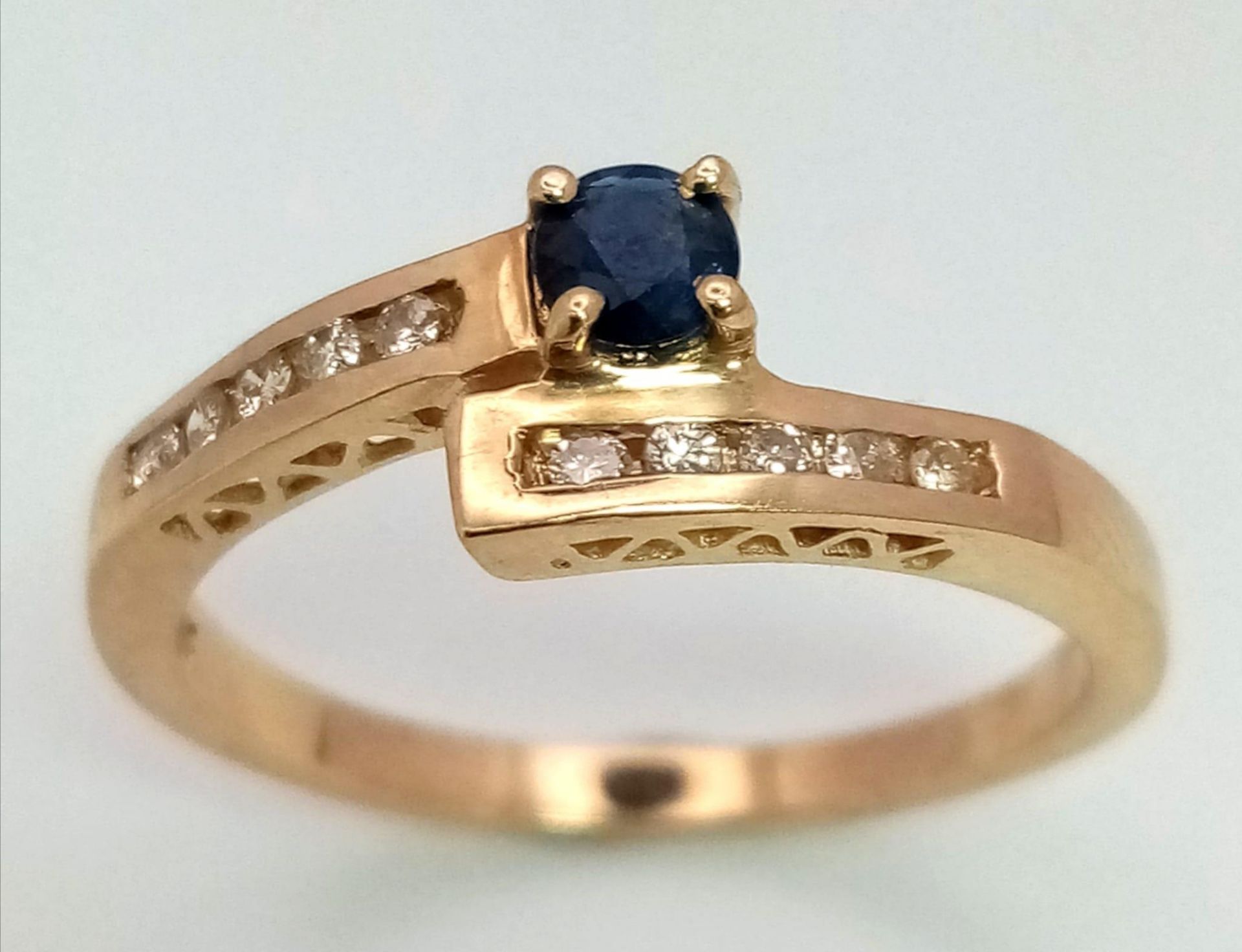 9K YELLOW GOLD DIAMOND & SAPPHIRE TWIST RING, SET WITH 0.15CT DIAMONDS AND 0.18CT SAPPHIRE, WEIGHT