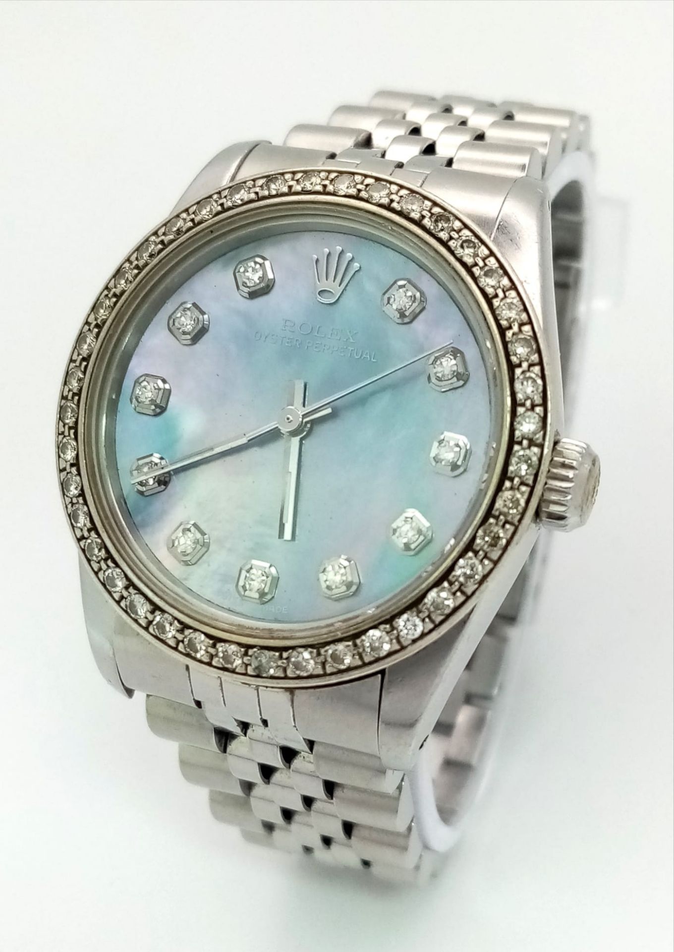 A ROLEX LADIES OYSTER PERPETUAL WRIST WATCH IN STAINLESS STEEL WITH DIAMOND BEZEL AND NUMERALS.