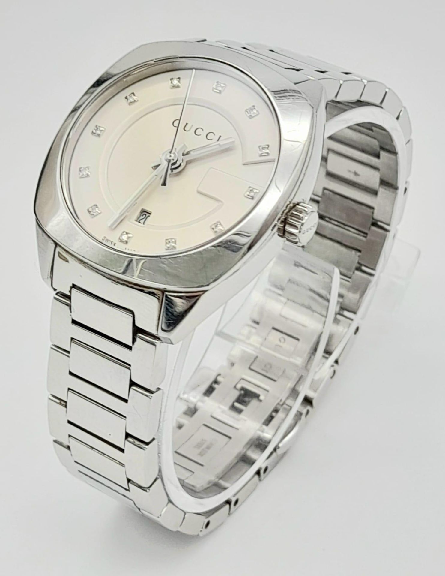A Gucci Quartz Ladies Watch. Stainless steel strap and case -29mm. Cream dial with date window and