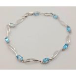 A 9K White Gold Blue Topaz Bracelet. Eight ice-blue topaz gemstones. 18cm. 4.57g total weight