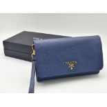 A Prada Blue Leather Clutch Bag. Textured blue leather with Prada logo in gold-tone. Zipped inner