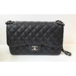 A Classic Chanel Jumbo Double Flap Bag. Quilted black caviar leather. Silver-tone hardware with