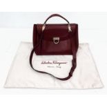 A Salvatore Ferragano Burgundy Leather Hand/Shoulder Bag. Rich burgundy leather exterior with gold-