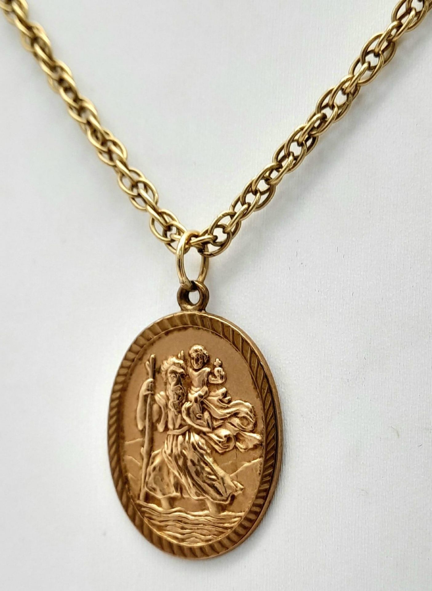 A 9K Gold Oval St. Christopher Pendant on a 9K Yellow Gold Chain/Necklace. 3cm and 64cm. 14.86g