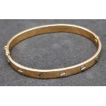 A 14K Yellow Gold Cartier-Style Bangle. Clip-open design for easy access. 62mm inner diameter. 22.