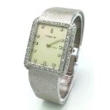 A CORUM 18K WHITE GOLD LADIES WATCH WITH DIAMOND BEZEL AND NUMERALS ON A SOLID 18K WHITE GOLD STRAP.