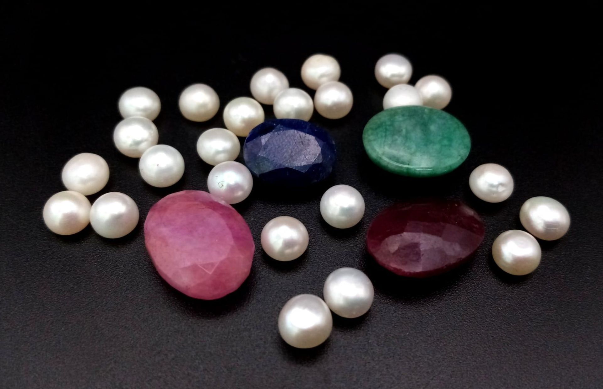 A mixed lot of faceted ruby and emerald and Cabochon Pearl Gemstones in total of 92.70ct