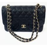 A Classic Chanel Jumbo Flap Bag. Black quilted caviar leather. Gold tone CC logo clasp. Entwined