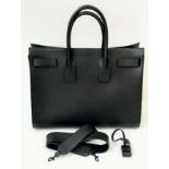 A Classy YSL Black Leather Sac de Jour Tote Bag. Textured calf leather exterior with twin handles.