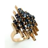 A modernist, 14 K yellow gold ring with a crown of sapphires arranged on a group of proud standing