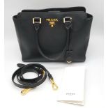 A Prada Black Leather Handbag with Adjustable Shoulder Strap. Textured leather with gold-tone