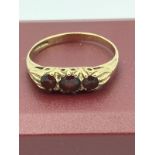 9 carat YELLOW GOLD RING With three round cut GARNETS Mounted to top. Complete with ring box. 1.5